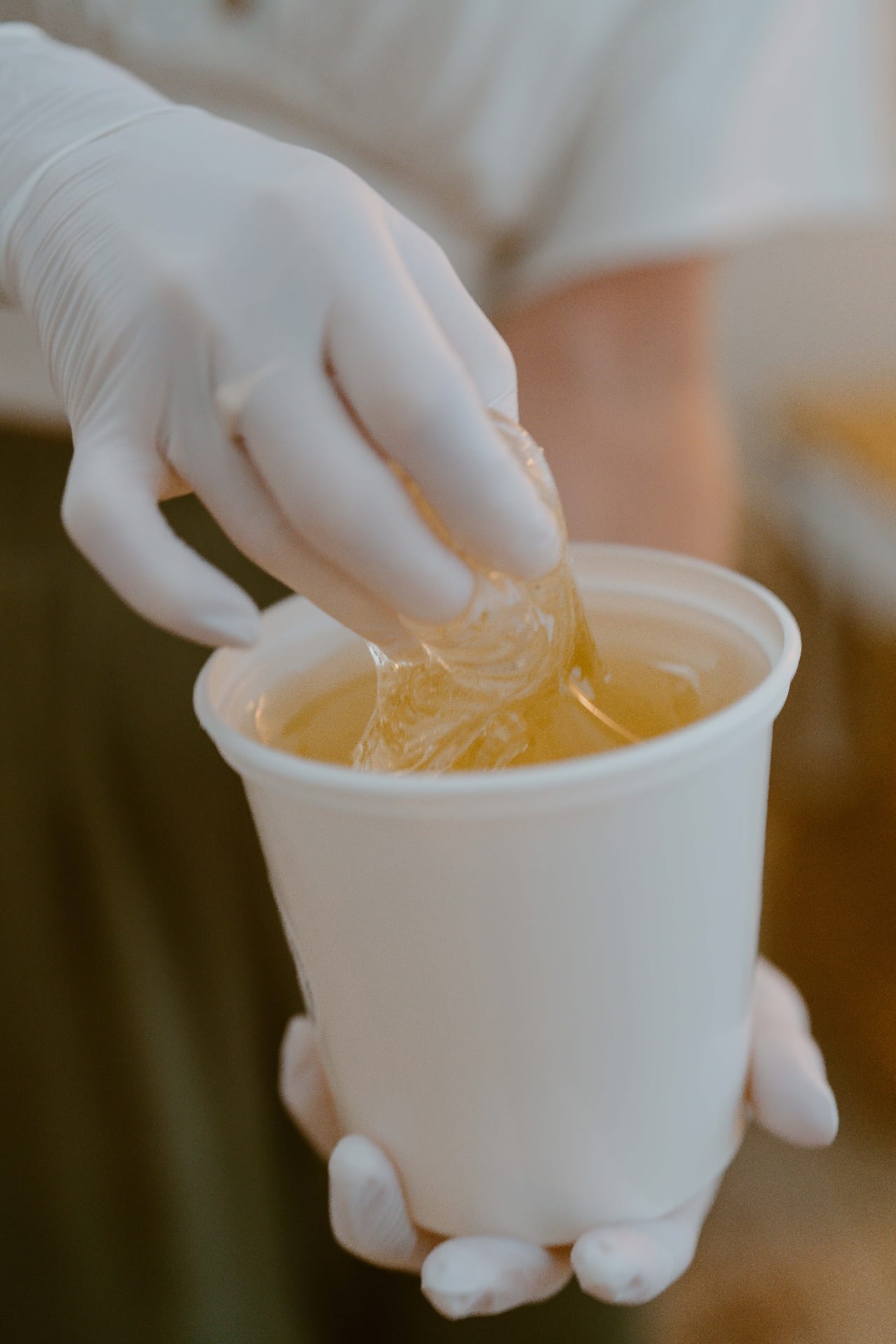 Gloved hand with golden organic sugar paste